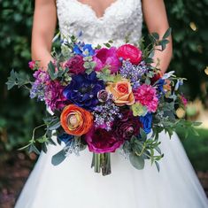 a bride holding a colorful bouquet of flowers