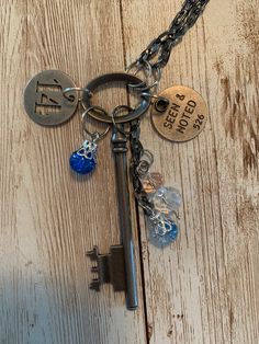 "A lovely set of charms hang off of a vintage style skeleton key. Each of the items and it's jump rings are in a variety of metal finishes. They hang off of a 13\" black stainless, box-like chain which could be adjusted if you would like. The variety of charms include two round tags; one with the sentiment, \"Seen and Noted\" engraved into it and an openwork number \"14\". The other charms are beads; two of which dangle from their own piece of chain and one which hangs on its own. Remember, this is a handmade item and can be quite delicate. This is not a toy. This is not intended for children; it is made from small parts and poses a safety hazard. Please use it only for its intended purpose and under strict adult supervision. Please examine all of the photos and be sure that this is the it Metal Jewelry With Keys For Gifts, Key Detail Metal Jewelry As A Gift, Metal Key Pendant Jewelry, Key Pendant Jewelry In Metal, Metal Key Necklace Perfect As Gift, Vintage Metal Jewelry With Keys Detail, Vintage Metal Jewelry With Keys, Vintage Metal Key Jewelry, Vintage Personalized Metal Charm Necklace