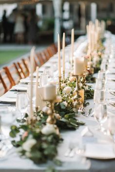 a long table is set with candles and flowers for an elegant dinner or wedding reception