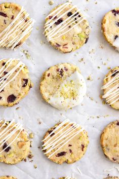 cookies with white icing and cranberry toppings on a sheet of wax paper