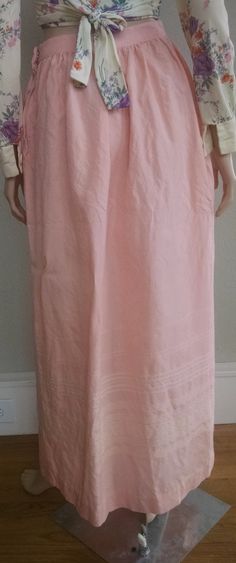 "This is a romantic high-waist pink maxi skirt from the 1950's. It is a delicate pink color with subtle cream embroidery at the bottom. The high waist quickly flares to a generous hip measurements (see below for exact measurements). Zipper and hook-and-eye closure on the left side, no pockets. The skirt fits like a modern small with the limiting factoring being the high waist measurement. The skirt is not lined and the fabric feels like a wool blend with a little stiffness and itchy-ness to it. Feminine Relaxed Maxi Skirt, Pink Flowy Skirt For Daywear, Pink Flowy Full-length Skirt, Relaxed Fit Maxi Skirt For Daywear, Pink Lined Skirt For Daywear, Relaxed Pink Skirt For Daywear, Pink Long Skirt For Daywear, Pink Long Pleated Dress, Flowy Maxi Skirt With Long Inseam For Spring