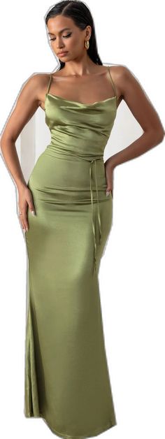 a woman in a green dress posing for the camera with her hands on her hips