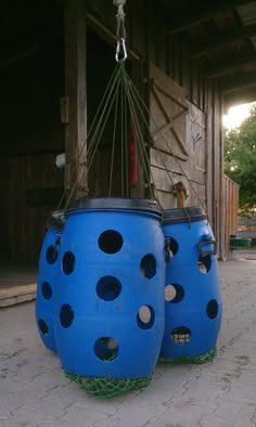 two large blue barrels with holes on them