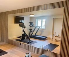 an exercise room with treadmills and television