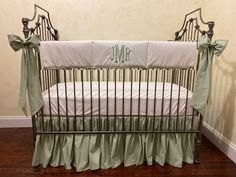 a baby crib with a monogrammed blanket and matching bedding is shown