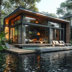 a floating house in the water surrounded by trees and greenery, with two lounge chairs