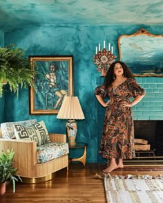 a woman standing in a living room with blue walls