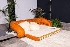 an orange and white couch sitting on top of a rug