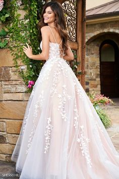 a woman in a wedding dress posing for the camera with her hand on her hip