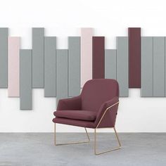 a purple chair sitting in front of a wall with grey and pink panels on it