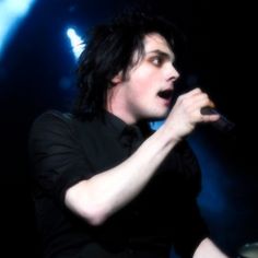 a male in a black shirt is holding a microphone