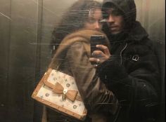 a man and woman taking a selfie in an elevator