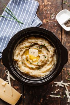 a bowl filled with mashed potatoes on top of a wooden table