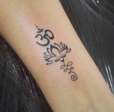 a small tattoo on the arm of a woman with an omen symbol in black ink