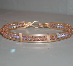 a gold bracelet with pink stones on it