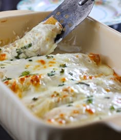 a spatula scooping cheese from a casserole dish