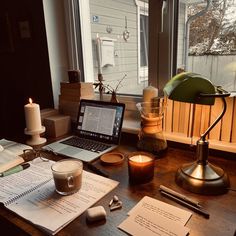 an open laptop computer sitting on top of a wooden desk next to a cup of coffee