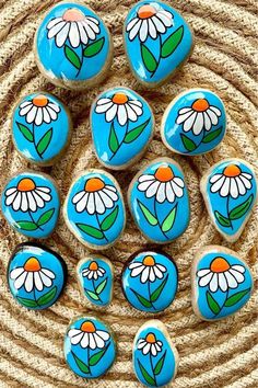 six painted rocks sitting on top of a rug