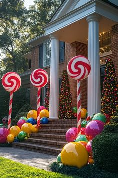 candy canes are lined up in front of a house with christmas decorations on the lawn