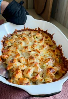 a casserole dish with cheese and meat in it on a white platter