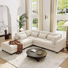 a living room with a large sectional couch and coffee table in front of two windows