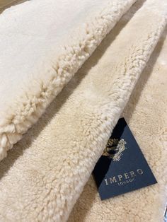 a close up of a white blanket with a tag on it's end and another item in the background