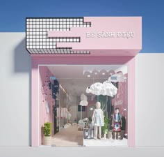 a pink store front with mannequins and umbrellas in the window display