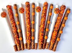 several sticks with basketballs on them are lined up in a row, one is orange and the other is white