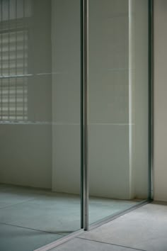 a white toilet sitting in the corner of a room next to a tall glass wall