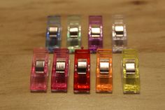 four different colored tape dispensers sitting on a wooden table next to each other