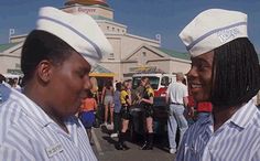 two men in sailor's hats standing next to each other at an outdoor event