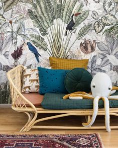 an octopus stuffed animal sitting on top of a couch in front of a tropical wallpaper