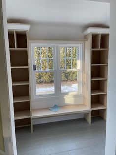 an empty room with shelves and a window