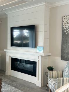 a living room with a large flat screen tv mounted on the wall above a fireplace