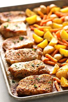 meat, potatoes and carrots on a baking sheet