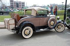 an antique car is parked in a parking lot