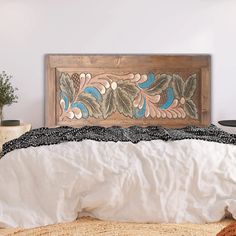 a bed with white linens and a wooden headboard on it's side