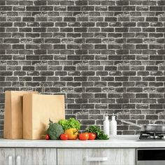 a kitchen with a brick wall and vegetables on the counter