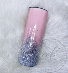 a pink and blue glitter tumbler sitting on top of a white fur covered floor