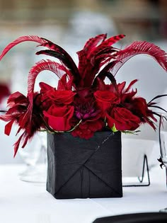 a vase with red flowers in it sitting on a table