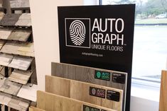 an autograph store display with wood flooring and signs on the wall behind it