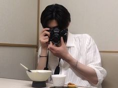 a man taking a photo of himself in front of a bowl of food with his camera