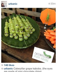 an image of grapes and carrots on a plate with stickers in the shape of eyes