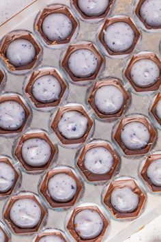 chocolate cupcakes with white frosting and sprinkles in an ice tray