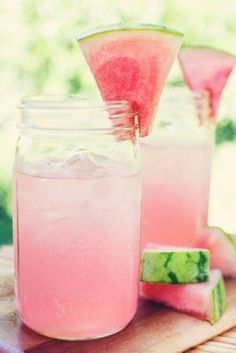 two mason jars filled with watermelon and limeade sitting on top of a cutting board