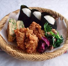 a wicker basket filled with different types of food on top of a tablecloth