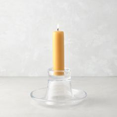 a single candle in a clear glass holder