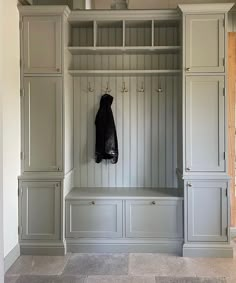 an empty mud room with gray cabinets and coat rack