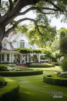 A stunning colonial-style home with a pristine white exterior, surrounded by meticulously manicured gardens, lush green lawns, and perfectly shaped hedges, offering a serene and elegant atmosphere. Colonial House Landscaping, Colonial Home Landscaping, Trimmed Hedges, Manicured Garden, Southern Mansions