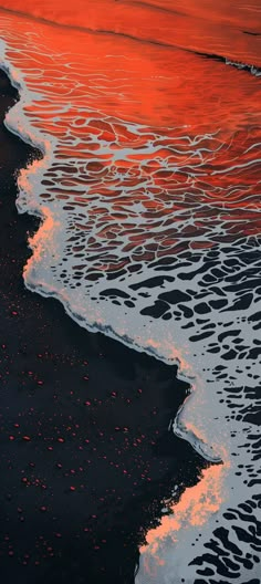 an orange sky is reflected in the water at sunset on a black sand beach with waves